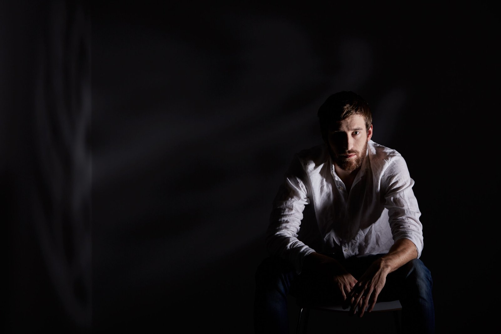Desperate man sitting alone in dark room