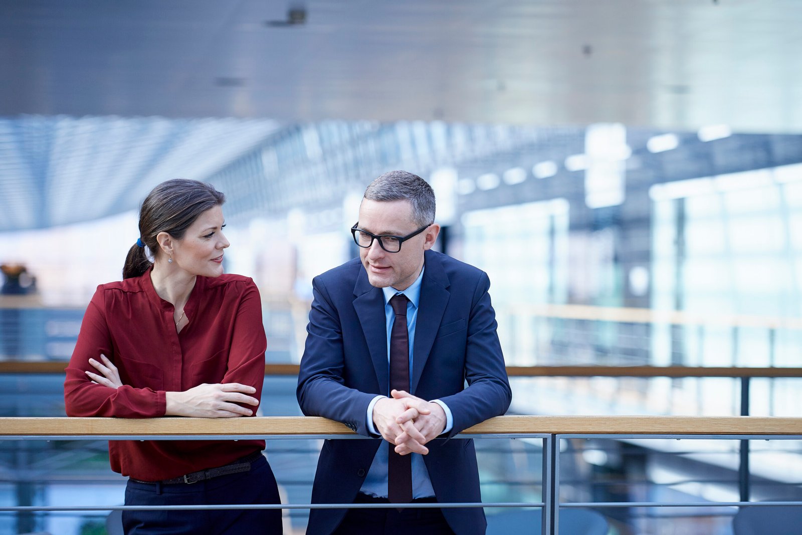 Businesswoman and man talking on office balcony