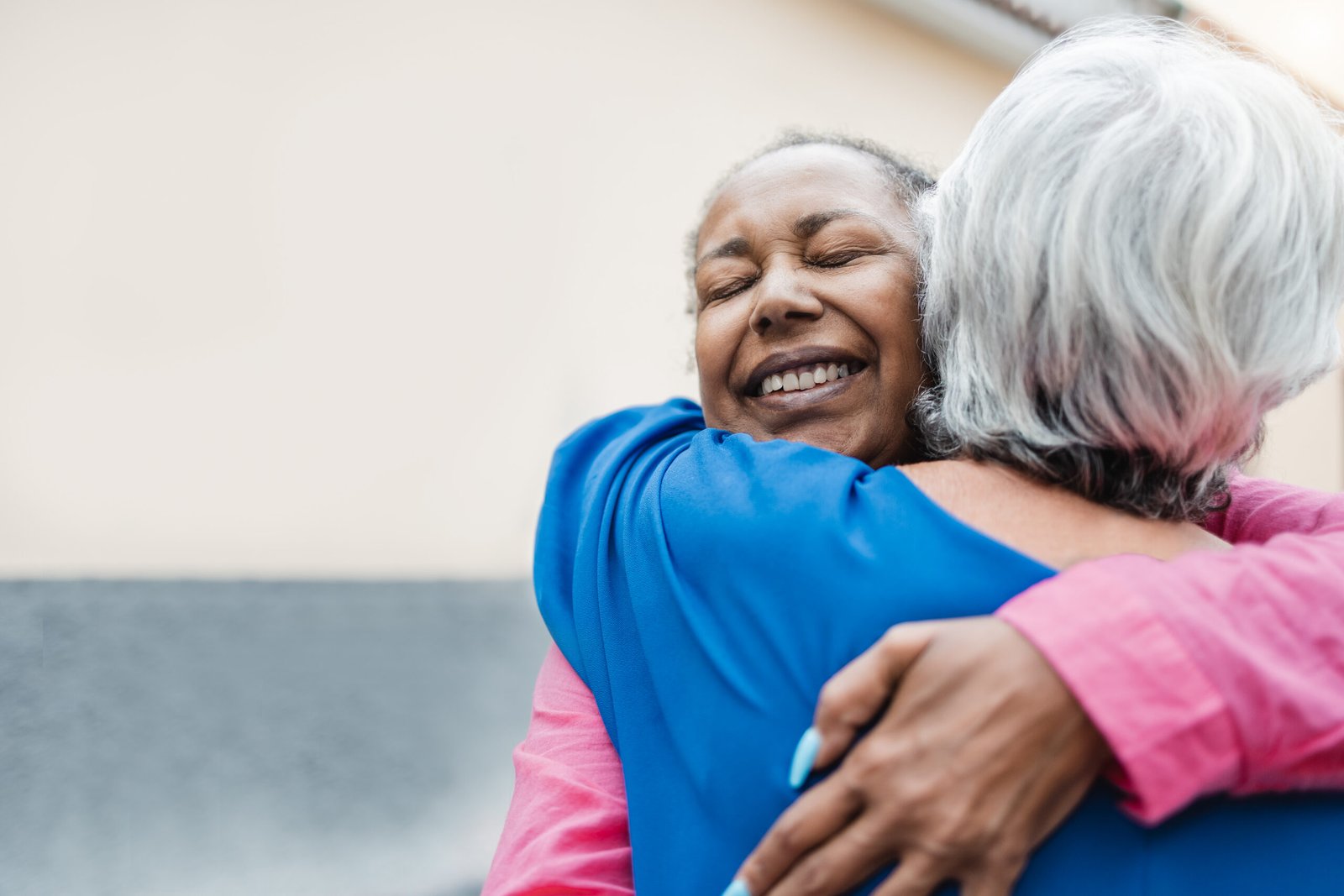 Multiracial senior women hugging each other - Elderly friendship and love concept - Focus on african woman face