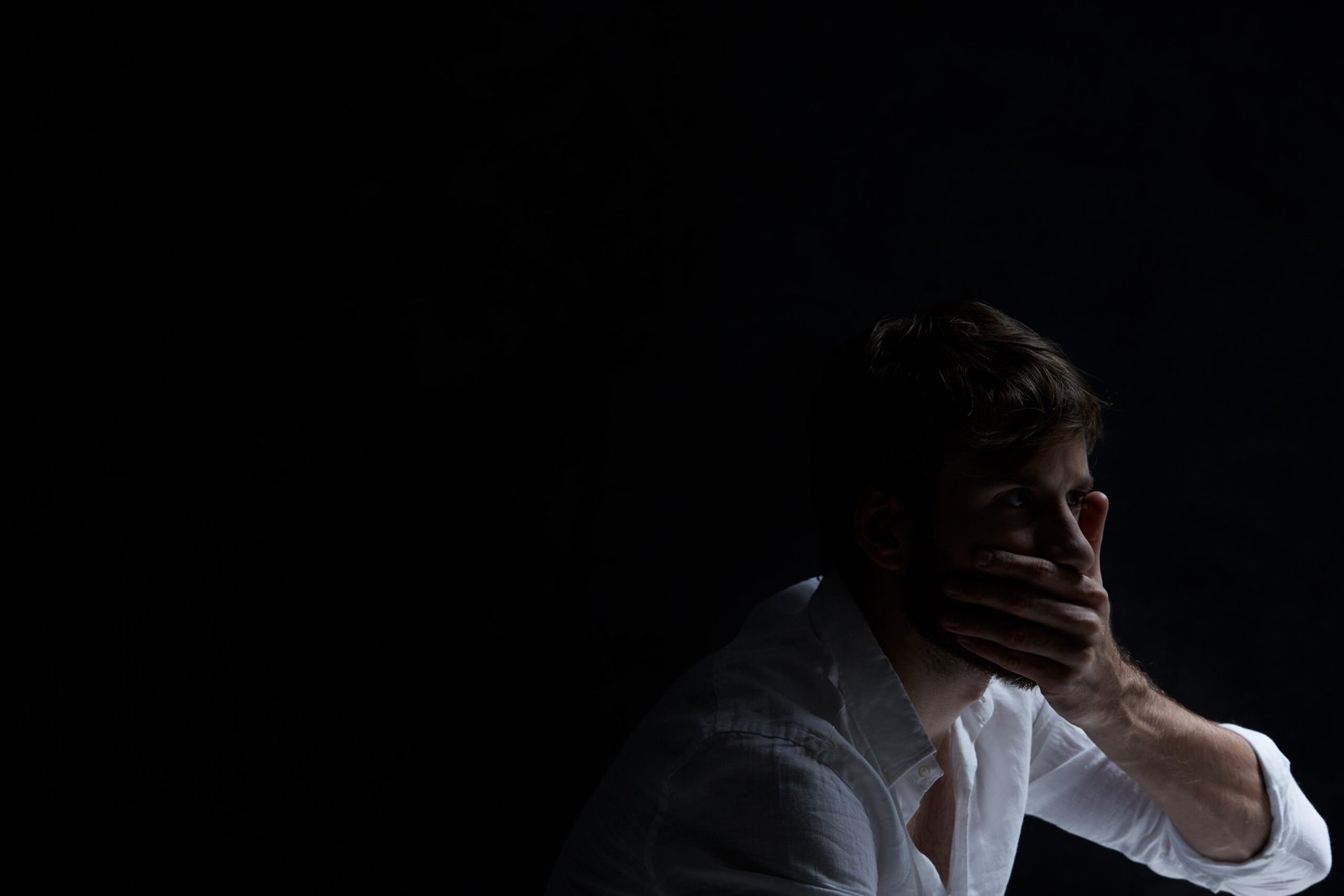 Alone man covering his mouth by his hand